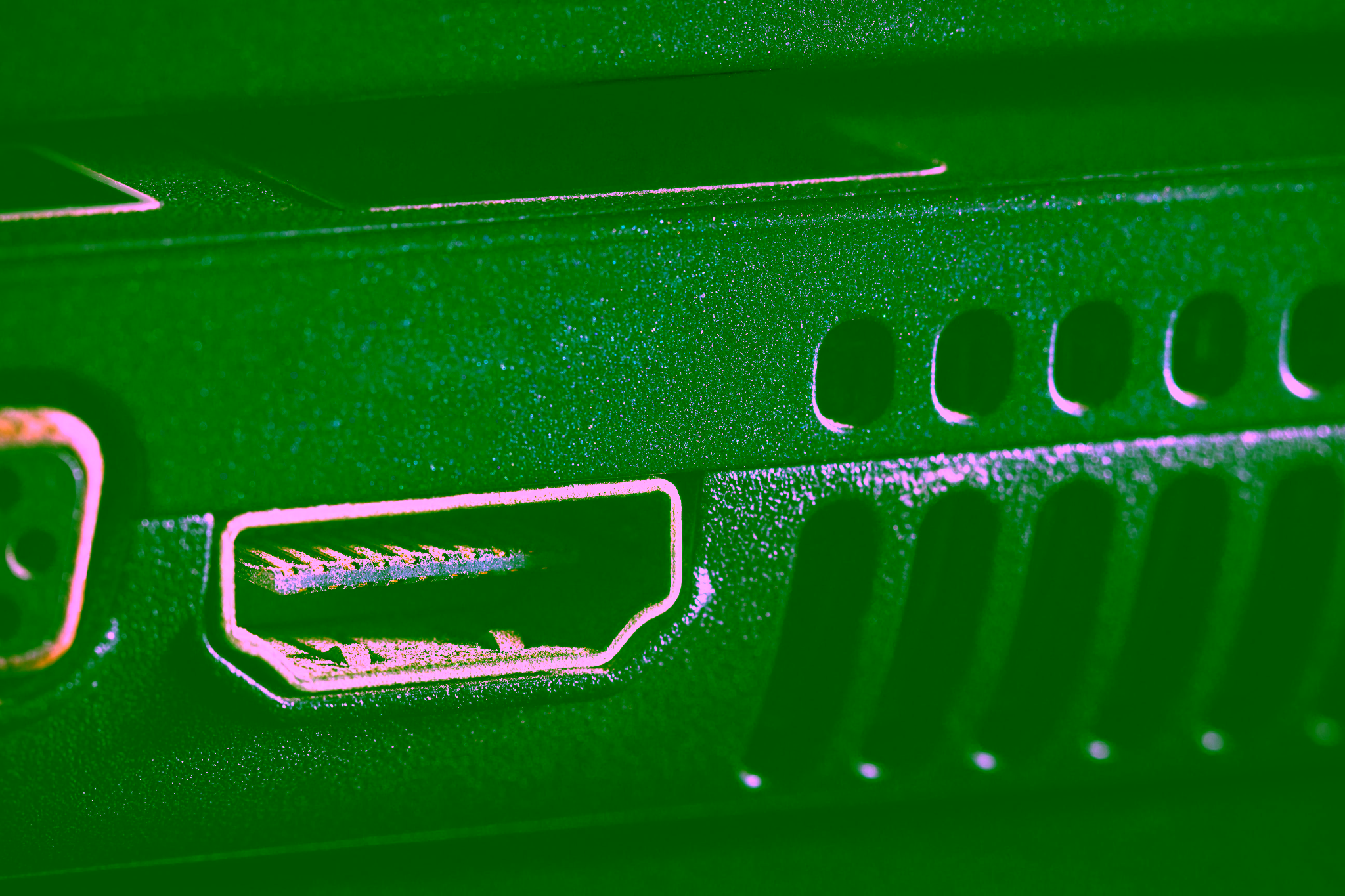 Nahaufnahme eines Playstation HDMI-Port an einem schwarzen elektronischen Gerät, mit sichtbaren Lüftungsschlitzen rechts neben dem Port.
